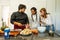 Chef teaching a young couple of different breeds how to cook