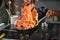 Chef tossing vegetables flambe in a pan over the burner