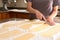 Chef trimming rolled pasta dough in a kitchen