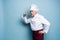 Chef trying meal. Confident mature chef in white uniform trying eating from wooden spoon and standing against blue