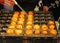 Chef turning takoyaki octopus balls on grill, Osaka, Japan