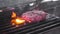 Chef turns the raw meat for the Burger on the hot grill. Lots of fire and smoke. Close-up, slow motion.