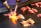 Chef using burnt torch prepares sushi