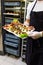Chef or waiter holding platter full of fresh canapes finger food snacks for buffet meal at restaurant