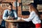 chef waiter takes an order from a young woman in a shirt a cup of coffee cafe restaurant