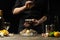 Chef watering raw oyster with lemon juice, with dry Italian wine, for cooking and cooking on a black background, Concept menu,
