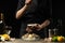 Chef watering raw oyster with lemon juice, with dry Italian wine, for cooking and cooking on a black background, Concept menu,