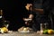 Chef watering raw oyster with lemon juice, with dry Italian wine, for cooking and cooking on a black background, Concept menu,