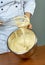 Chef whips yellow cream in a bowl by hand for making cheesecakes