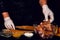 The chef in white gloves rubs pieces of pork with spices, uses curry, basil and salt, marinates the meat on a barbecue