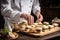 chef in a white hat arranging tea sandwiches on a vintage styled tray