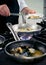 Chef at work with fried mussels