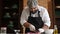 Chef works on a kitchen and cuts red onion with a knife on a cutting board, Medium shot