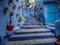 Chefchaouen the Blue city in Morocco with colourful pots decorating a blue stairwell