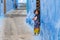 Chefchaouen, Morocco - APRIL 30 2019: View of a narrow blue street with a small moroccan child