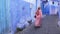 Chefchaouen, Tetouan, Morocco - July 28, 2022: Street scene with a traditionally dressed woman.