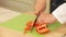 Cheff is Slicing Red Paprika on a Cutting Board