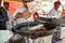 Chefs at a booth make Jalebi Indian spiral fried dough funnel cakes at the Surajkund Crafts