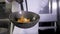 Chefs cooks and doing flambe on vegetables in wok on restaurant kitchen