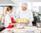 Chefs Discussing While Holding Pasta Tray In