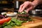 chefs hand garnishing a black bean burger with herbs