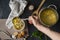 chefs hand pour fresh hot soup in a white empty bowl, food preparations