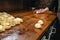 Chefs Hand Preparing Round Pieces of Dough