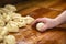 Chefs Hand Preparing Round Pieces of Dough