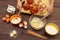 Chefs hands with baked buns on the background of ingredients on wooden table