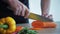 Chefs Hands Chopping Carrot On Wooden Board
