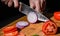Chefs hands chopping onion on wooden board