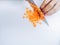 Chefs hands chopping slicing carrots into pieces on white cutting board