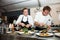 Chefs making and serving gourmet meals at food festival vendor stall