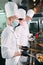 Chefs in protective masks and gloves prepare food in the kitchen of a restaurant or hotel.