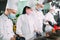 Chefs in protective masks and gloves prepare food in the kitchen of a restaurant or hotel.