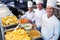 Chefs standing at serving trays of pasta