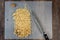 Chefâ€™s knife and a pile of partially chopped raw walnuts on a plastic cutting mat, ready for baking