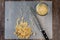 Chefâ€™s knife and a pile of partially chopped raw walnuts on a plastic cutting mat, small glass bowl with chopped nuts