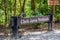 Chek Jawa Wetlands Nature Preserve wooden sign with monkey Long-tailed macaque sitting on it