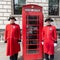 Chelsea pensioners in London standing near a red telephone box.