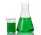 A chemical flask, beaker with green liquids and sheet of paper w