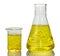 A chemical flask, a beaker with yellow liquids and a sheet of pa