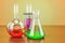 Chemical flasks with colored liquid on the wooden table. 3D rend