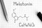 Chemical formula of Melatonin with black pen