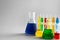 Chemical glassware with colorful samples on light background