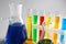 Chemical glassware with colorful samples on light background, closeup