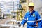 Chemical industry plant - workers in work clothes in a refinery with pipes and machinery