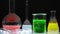 Chemical laboratory glassware with liquids inside on black background