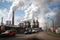 chemical plant, with smoke rising from chimneys, and trucks transporting raw materials