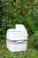 Chemical portable toilet. Single portable toilet standing on green nature courtyard background